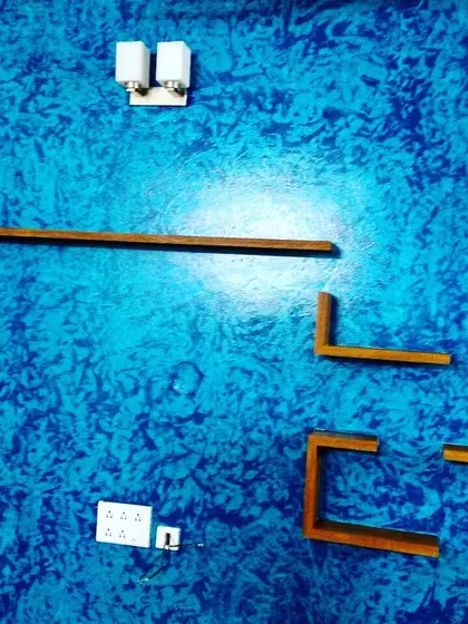 This vibrant blue wall demonstrates a crinkle texture effect, a popular choice for adding character and hiding minor wall imperfections. It serves as a dynamic background for the minimalist wooden shelves in this living space.