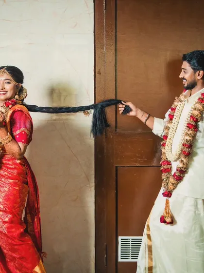 A playful shot of the groom holding the bride's long, traditional braid. It's these fun moments that make a wedding memorable.