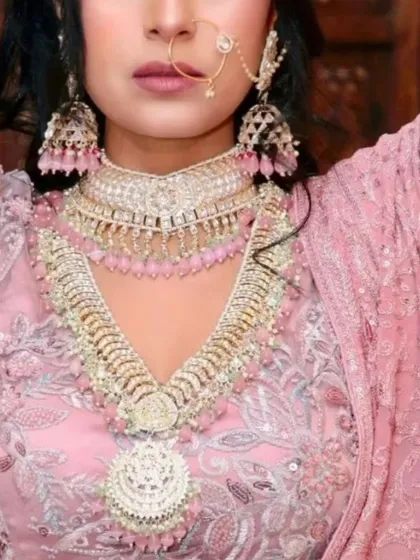 This look shows how we can play with colour. The layered Polki and pearl set is customized with soft pink beads to perfectly match the bride's pastel pink lehenga, creating a cohesive and modern bridal style.