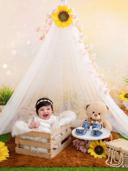 A happy smile from this four-month-old, enjoying her milestone session in a bright and cheerful sunflower setting.