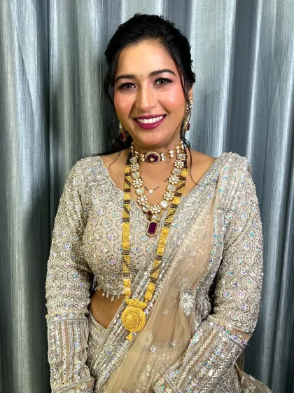 A second reception look for the bride. A shimmering lehenga paired with a bold lip and glowing skin.