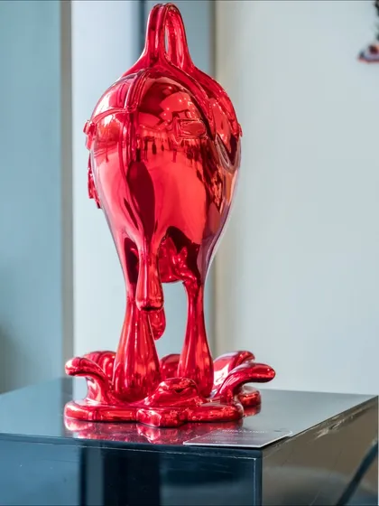 The "Melting Affection" sculpture from a side angle, showing the dramatic drips of the melting heart-shaped bag.