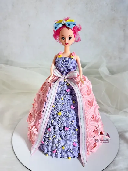 Another take on the classic doll cake, this time with a beautiful piped dress in shades of pink and purple, finished with a lovely ribbon.