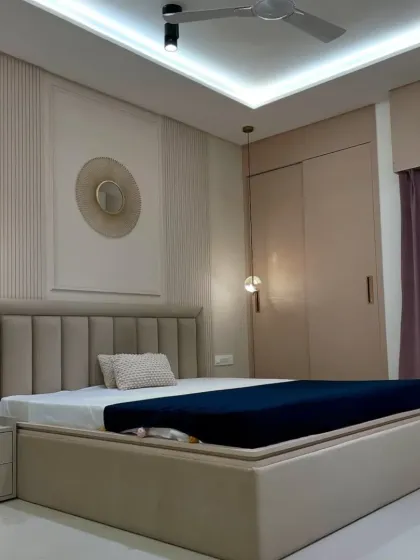 A chic and modern bedroom in neutral tones. The vertically paneled accent wall, stylish pendant lights, and sliding wardrobe create a sophisticated and clutter-free space.