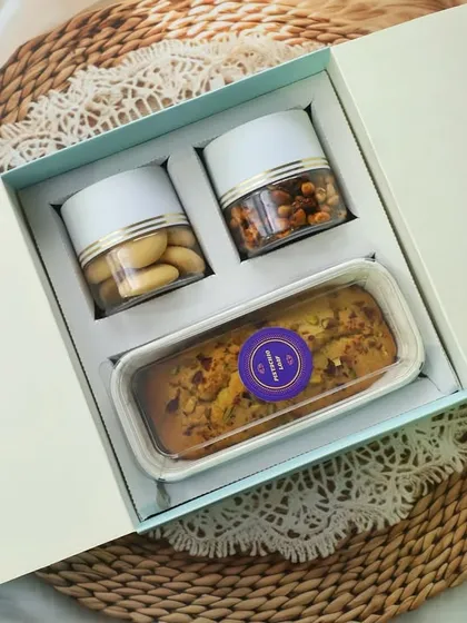 Gifting made easy and elegant. This hamper features my signature Badam Rawa Loaf, classic cookies, and savory peanuts, all in a convenient and stylish carry-box.