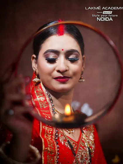 A close-up of a Karwa Chauth makeup look. The focus is on the shimmery eyeshadow, bold red lip, and the traditional sieve (chhalni), capturing the spirit of the festival.