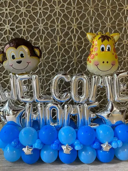 A sweet "Welcome Home" balloon bouquet, perfect for celebrating a new baby. This arrangement features cute monkey and giraffe foil balloons on a base of blue and silver balloons.