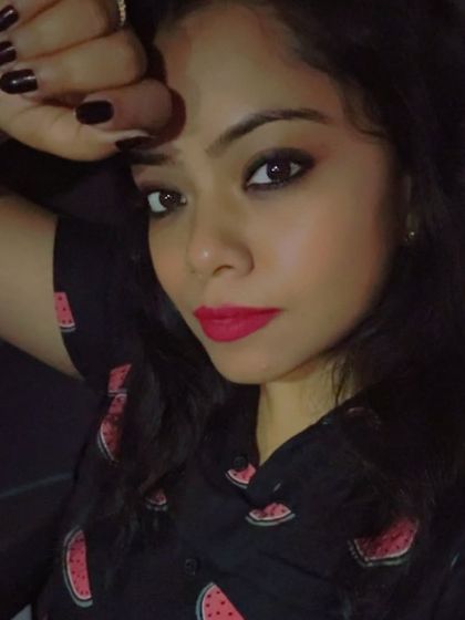 A close-up selfie showing a bright pink lip and dark nails, contrasting beautifully with the watermelon-print dress.