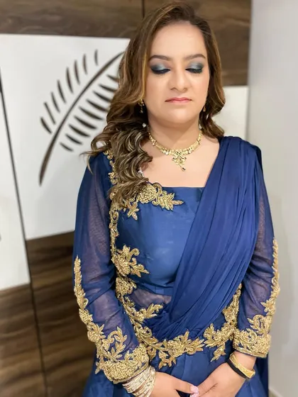 A glamorous evening look for a wedding guest. This features a dramatic smokey eye in shades of blue and silver, paired with soft curls for a stunning party-ready style.