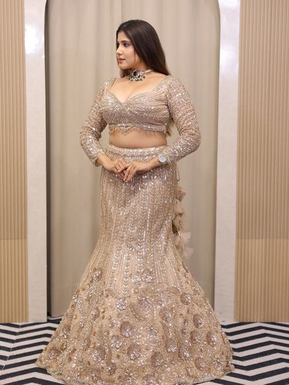 A side profile of the champagne sequin lehenga, showcasing its sleek silhouette and shimmering texture.
