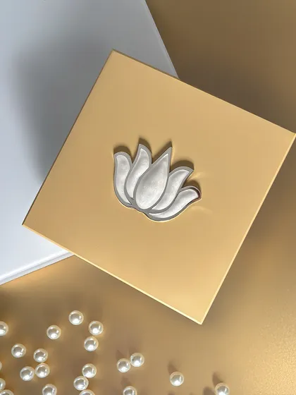 A close-up of the silver lotus motif on the golden lid. This design adds meaning and beauty in one thoughtful package, symbolizing purity and enlightenment.