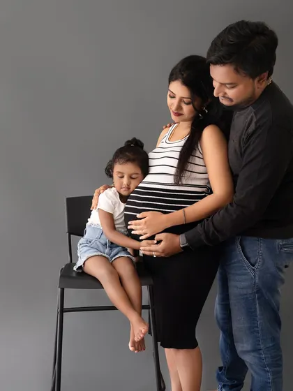 An incredibly sweet and tender moment where the older sister hugs her mom's baby bump, showing her love for her new sibling.