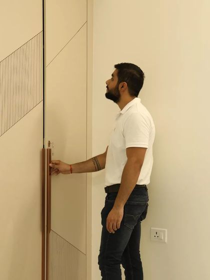 A close-up of a wardrobe with a unique grooved pattern and long, modern handles.