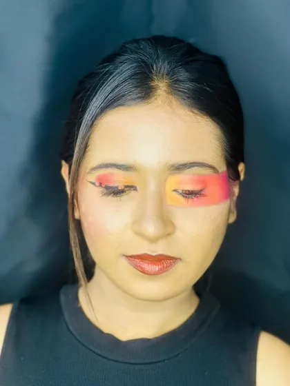 A view with eyes closed to showcase the full color gradient of the sunset-inspired makeup. You can see the seamless blend from vibrant red to warm yellow across the eyelid.