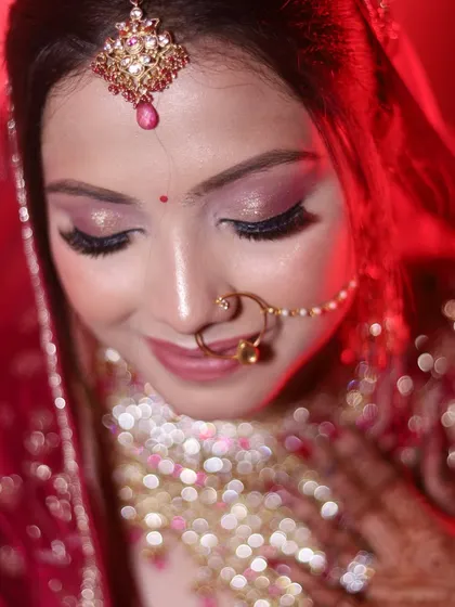 This close-up shot with a beautiful bokeh effect focuses on the bride's shimmering eye makeup and delicate nath. It’s all about capturing the fine details.