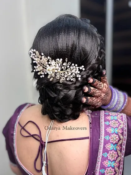 Another angle of this popular braided bun hairstyle. It's a versatile look that works well with both sarees and lehengas, making it a great choice for any wedding event.
