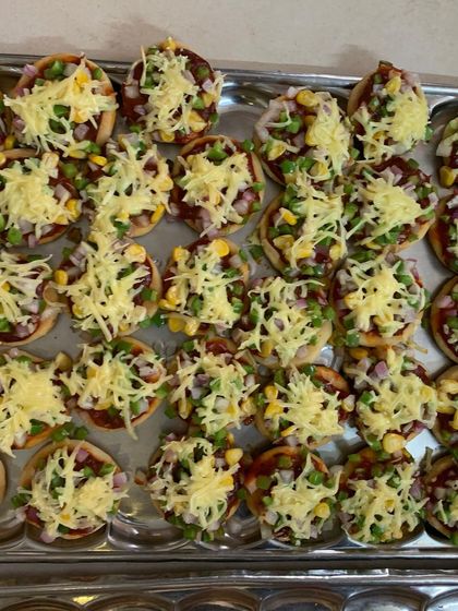 A tray of my mini pizzas, topped with cheese and veggies, ready to be served at a party. They are always a crowd-pleaser.