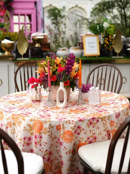 A beautiful floral table centerpiece with a printed tablecloth. The combination of fresh flowers and elegant linens elevates the dining experience for guests.