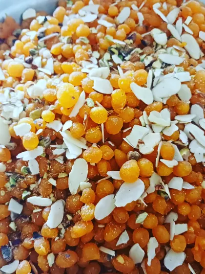 Sweet boondi prepared as a prasad offering. These tiny, sweet pearls are completely plant-based and perfect for pujas and festive occasions, garnished with sliced almonds and pistachios.