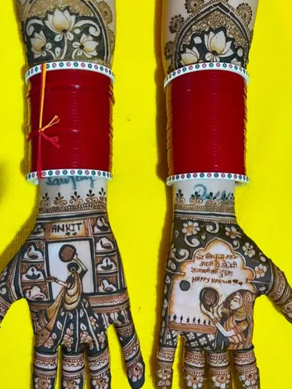 A personalized Karwa Chauth mehndi with the husband's name, 'Ankit', written on the palm. The design shows the wife with her puja thali, surrounded by intricate patterns.