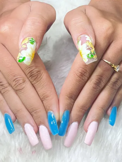 A creative and colorful set combining solid colors with floral nail art. This demonstrates the versatility our students gain in their design skills.
