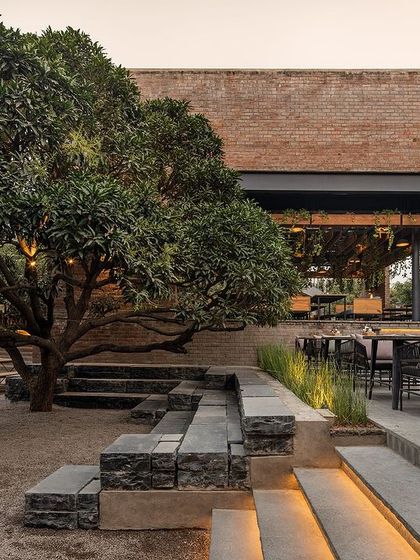 Stepped seating with integrated lighting at Zero40 Brewery, set under the canopy of a large tree. This feature provides informal seating and adds a dramatic flair to the landscape, enhancing the evening ambiance.