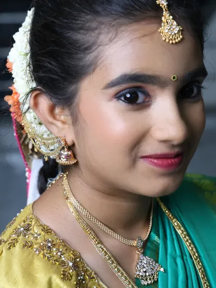 A close-up of the makeup for a half-saree look, featuring soft, shimmery eyeshadow and neatly defined brows.