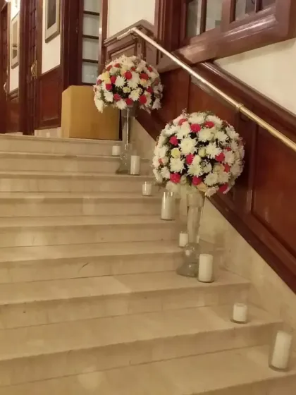 An elegant staircase decoration. I placed large floral bouquets on glass stands and surrounded them with candles to create a warm and inviting path.