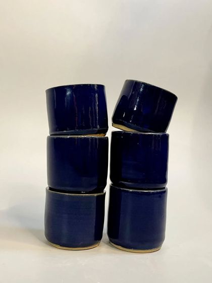 A stack of the cobalt blue tumblers. Their simple, elegant design seamlessly blends into your daily routine, transforming ordinary moments.