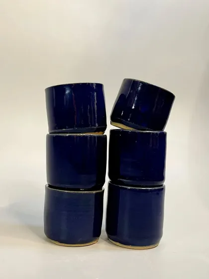 A stack of the cobalt blue tumblers. Their simple, elegant design seamlessly blends into your daily routine, transforming ordinary moments.