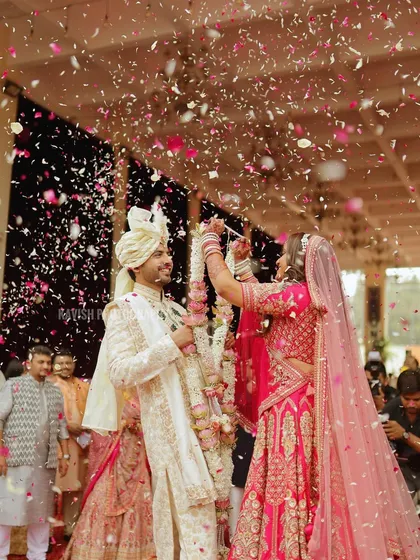 A wide shot of the couple during the flower petal shower, capturing the grandness of the moment.