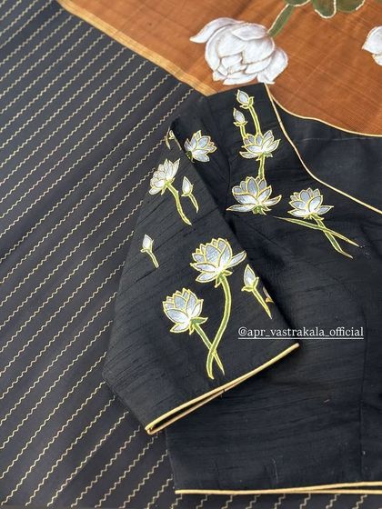 An elegant black blouse featuring hand-painted white lotuses. The simplicity of the design and the clean lines make this a sophisticated and modern choice.