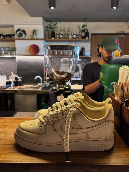 Another shot of the coffee custom sneakers in a cafe setting.