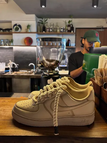 Another shot of the coffee custom sneakers in a cafe setting.