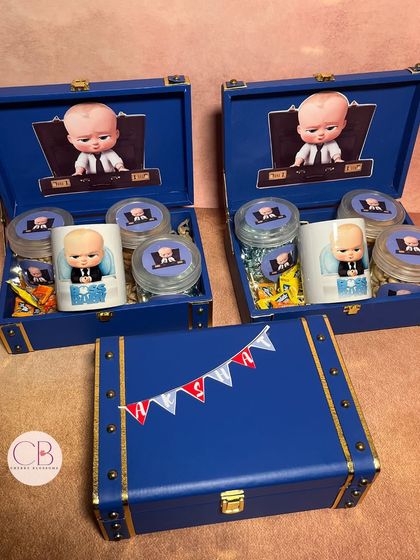 Our "Boss Baby" return favours are available in different styles. This version comes in a luxury blue leatherette trunk box, filled with a custom mug and jars of treats.