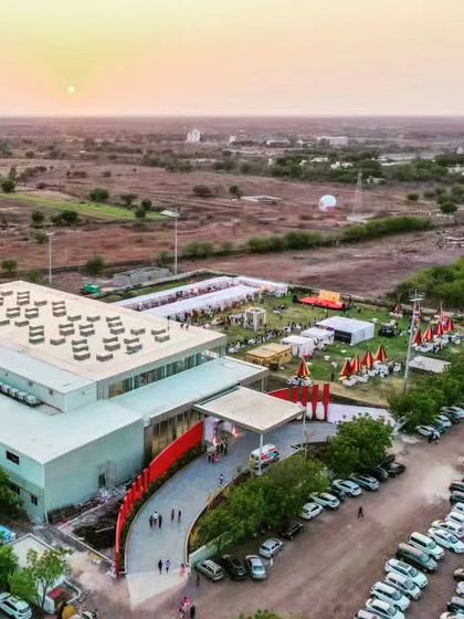 A sunset aerial view of the Glass Pavilion, capturing the building in the context of the wider, rural landscape.