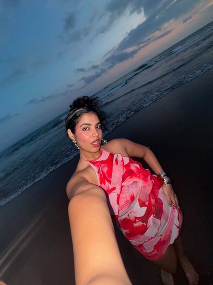 A beach selfie at sunset. The colors of the sky are reflected in my red and pink floral dress, creating a beautiful, cohesive image.