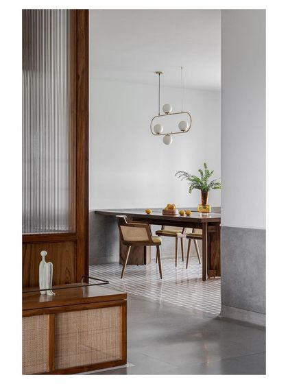 A view from a hallway into a dining area, showing how I use materials like fluted glass and rattan to create layered views and a sense of discovery.
