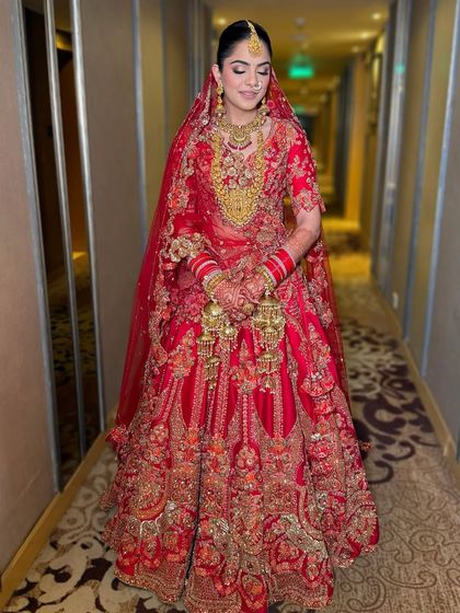 The complete regal red bridal look, from the makeup to the outfit. The glowing skin and defined eyes create a look that is both classic and unforgettable.