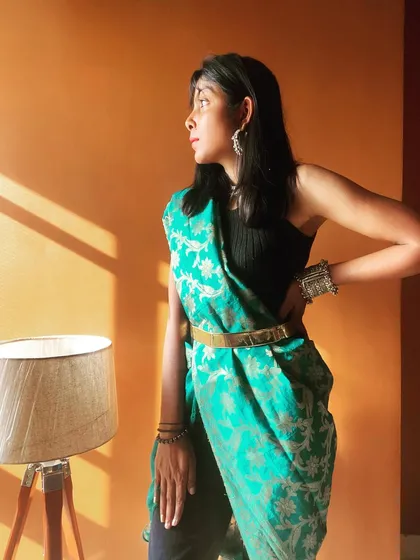 This is another take on the modern pant-saree look. I've draped a vibrant turquoise Banarasi dupatta over a black top and pants, securing it with a sleek gold belt. The look is finished with oxidized silver jewelry, creating a beautiful contrast and a perfect Indo-Western fusion outfit.