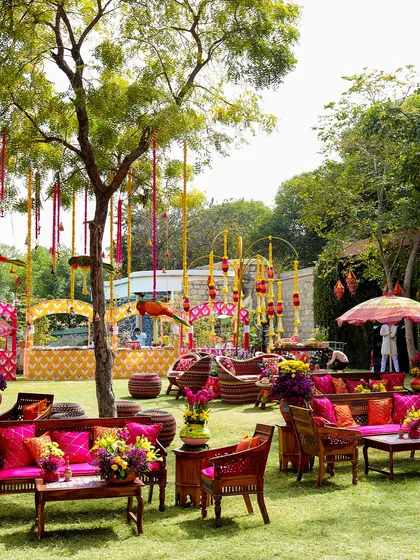 The seating area at the "Raangon ka Jashn" carnival, filled with bright pink and orange cushions, traditional wooden furniture, and hanging floral decor. The entire space was a celebration of color.