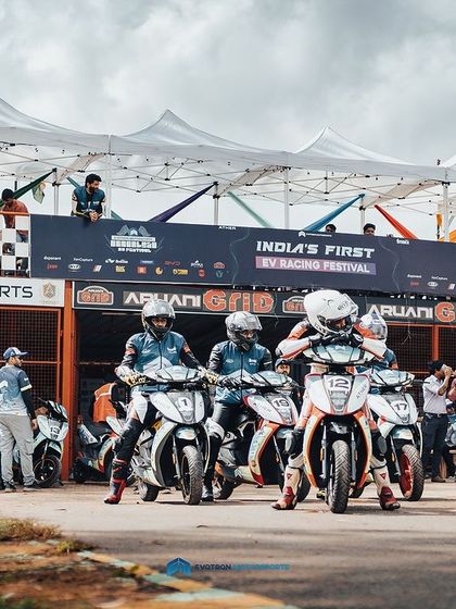 Riders heading out of the pit lane at India's first EV racing festival. It's an awesome sight to see a full grid of electric scooters ready to compete.
