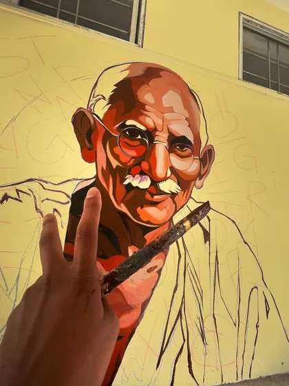 A work-in-progress shot of the Mahatma Gandhi portrait. Even during the painting process, the powerful likeness and character of the figure begins to emerge.
