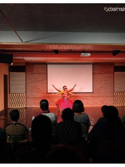 A graceful moment from the Attakkalari performance, where a solo dancer captivates the audience with her expressive movements.