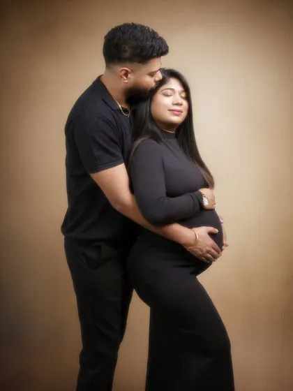 A tender kiss on the forehead, a protective embrace. This classic portrait pose, set against a warm, painterly background, is all about love, security, and the beautiful journey they are on together.