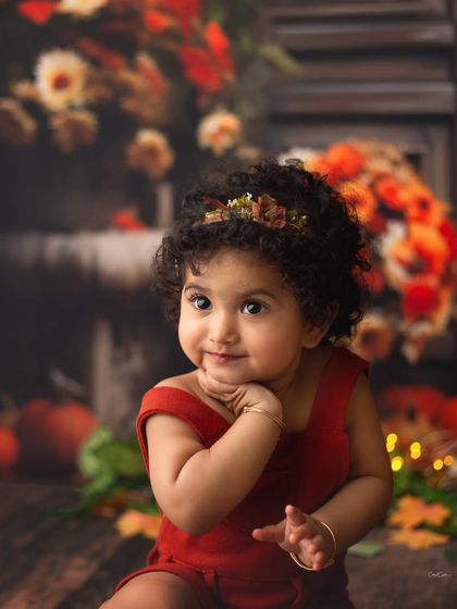 A pensive, pretty pose from this little model. Her curly hair and sweet expression are the focus of this beautiful autumn portrait.
