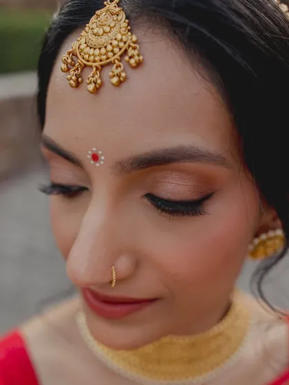 A close-up on the makeup details for this Bengali bride. Soft eyeshadow, a perfect winged liner, and a traditional bindi create a look that is both rooted and radiant.