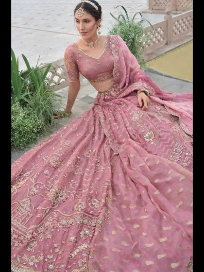 This seated portrait offers a closer look at the rich embroidery on the skirt and the sheer, elegant blouse.