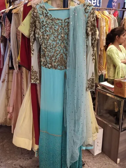 This stunning turquoise Anarkali gown features intricate gold embroidery on the bodice and full sleeves. Complete with a sequined dupatta, it's a complete, ready-to-wear outfit for any wedding function.