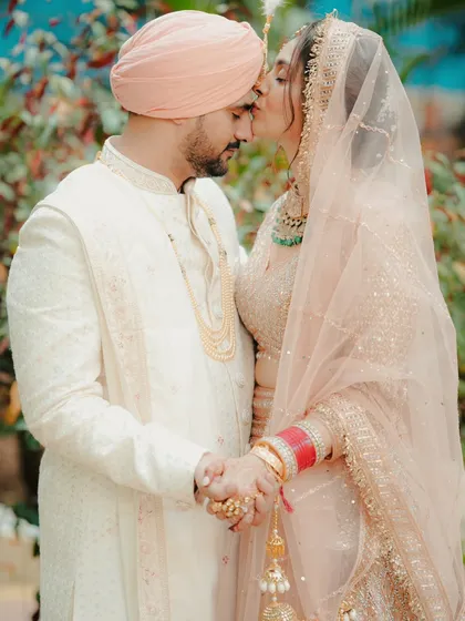 A beautiful, intimate portrait of a Sikh couple. The bride's gentle kiss on the groom's forehead shows their deep love and affection.